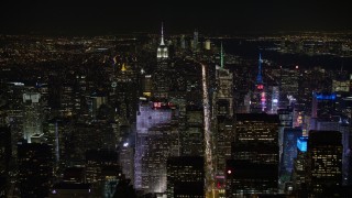 4.8K aerial stock footage view fly over Rockefeller Center and follow 6th Street in Midtown Manhattan at night, New York City, New York Aerial Stock Footage | AX67_0018