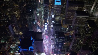 AX67_0023 - 4.8K aerial stock footage view of tilting to a bird's eye view of bright lights of Time Square in New York City, New York