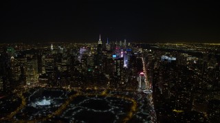 4.8K aerial stock footage view of Times Square, skyscrapers, and Columbus Circle in Midtown Manhattan at night in winter, New York City, New York Aerial Stock Footage | AX67_0026