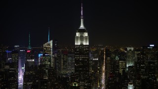 AX67_0049 - 4.8K aerial stock footage view of the Empire State Building and Midtown skyscrapers at night, Midtown Manhattan, New York City, New York