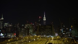 4.8K aerial stock footage view of the Empire State Building at night seen from Hudson Yards, Midtown, New York Aerial Stock Footage | AX67_0062