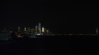 4.8K aerial stock footage view of tilting from the Hudson River to reveal the World Trade Center skyline at night, New York Aerial Stock Footage | AX67_0064