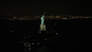 4.8K aerial stock footage view of orbiting the back of the Statue of Liberty at night, New York Aerial Stock Footage | AX67_0073