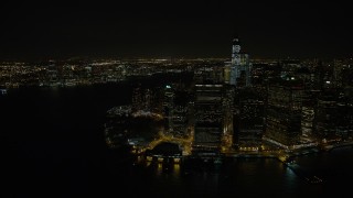 AX67_0083 - 4.8K aerial stock footage view of orbiting Lower Manhattan skyscrapers and Battery Park at night, New York