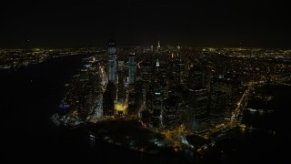 AX67_0084 - 4.8K aerial stock footage view of orbiting Battery Park and Lower Manhattan's tall skyscrapers at night, New York