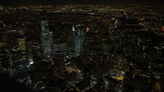 AX67_0085 - 4.8K aerial stock footage view of orbiting tall skyscrapers in Lower Manhattan and the World Trade Center at night, New York