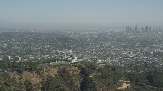 AX68_004 - 4.8K aerial stock footage Griffith Observatory with a view of Downtown Los Angeles skyline, California