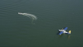 AX68_062 - 4.8K aerial stock footage of speedboat and a seaplane in San Pedro Bay, Long Beach, California