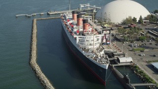 AX68_065 - 4.8K aerial stock footage of passing the starboard side of the Queen Mary luxury liner in Long Beach, California