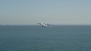 AX68_079 - 4.8K aerial stock footage of tracking seaplane approaching the San Pedro Bay breakwater, Long Beach, California