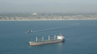 4.8K aerial stock footage of a barge sailing near an oil tanker in San Pedro Bay near the coast, Long Beach, California Aerial Stock Footage | AX68_082