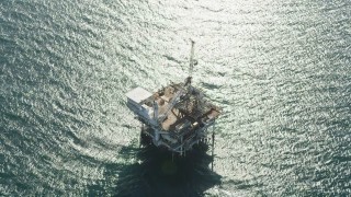 4.8K aerial stock footage of tilt to a bird's eye view of an oil derrick near Long Beach, California Aerial Stock Footage | AX68_108