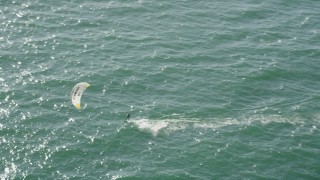 AX68_119 - 4.8K aerial stock footage of tracking a kite surfer cruising across San Pedro Bay, Long Beach, California