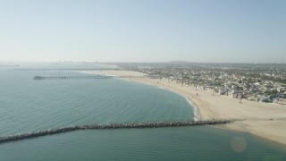 4.8K aerial stock footage fly over breakwater to approach the pier by beach and homes, Seal Beach, California Aerial Stock Footage | AX68_122