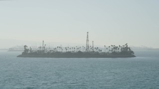 AX68_126 - 4.8K aerial stock footage approach the oil drilling Island Chaffee in San Pedro Bay, Long Beach, California