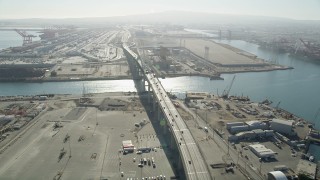 AX68_140 - 4.8K aerial stock footage follow light I-710 traffic to the Gerald Desmond Bridge at the Port of Long Beach, California