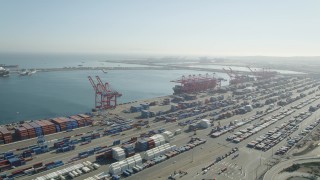 AX68_142 - 4.8K aerial stock footage of cargo containers and ships under cranes at the Port of Long Beach, California