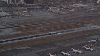 AX69_014 - 4.8K aerial stock footage track passenger jet landing on runway at sunset at LAX, Los Angeles, California