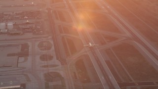 AX69_016 - 4.8K aerial stock footage track an airliner at sunset as it lands at LAX, Los Angeles, California