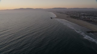 AX69_025 - 4.8K aerial stock footage tilt to reveal Venice Fishing Pier and empty beach to Santa Monica at sunset, California