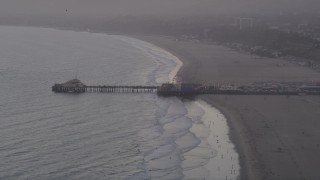 4.8K aerial stock footage of Santa Monica Pier at sunset and people walking the beach, California Aerial Stock Footage | AX69_028