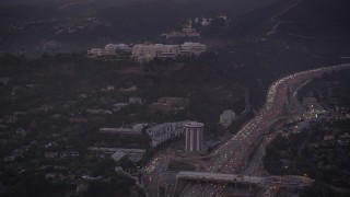 4.8K aerial stock footage of J. Paul Getty Museum, Hotel Angeleno, and I-405 with heavy traffic at twilight, Brentwood, California Aerial Stock Footage | AX69_054