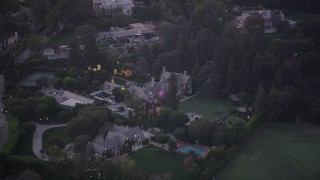 AX69_062 - 4.8K aerial stock footage of orbiting the Playboy Mansion in Los Angeles, California, twilight