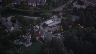 An orbit around The Playboy Mansion at twilight in Los Angeles, California Aerial Stock Footage | AX69_064