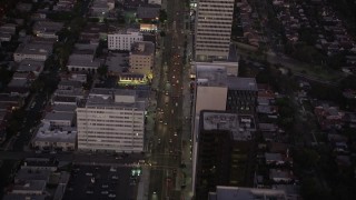 4.8K aerial stock footage follow Wilshire Boulevard past office buildings in Beverly Hills, California, twilight Aerial Stock Footage | AX69_071