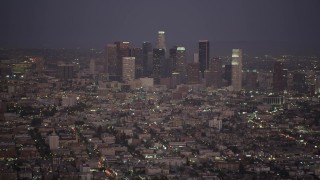 4.8K aerial stock footage tilt from apartment buildings to reveal and approach Downtown Los Angeles at night, California Aerial Stock Footage | AX69_076