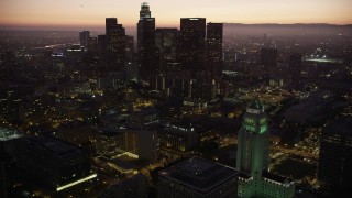 AX69_085 - 4.8K aerial stock footage orbit Los Angeles City Hall and reveal skyscrapers in Downtown Los Angeles at twilight, California