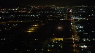 AX69_158 - 4.8K aerial stock footage of small airplane landing at Whiteman Airport at night in Pacoima, California