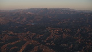 4K aerial stock footage Fly over Los Padres National Forest to approach a lake at sunrise, California Aerial Stock Footage | AX70_005