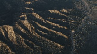 4K aerial stock footage Dry riverbed by mountain ridges in Los Padres National Forest at sunrise, California Aerial Stock Footage | AX70_021