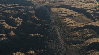 4K aerial stock footage Dry riverbed between mountain ridges in Los Padres National Forest at sunrise, California Aerial Stock Footage | AX70_022