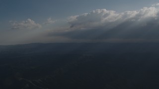 4K aerial stock footage Flyby godrays shining on mountains from the clouds over San Luis Obispo County, California Aerial Stock Footage | AX70_079