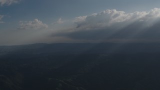 4K aerial stock footage Rays of sunlight shining on mountains from the clouds over San Luis Obispo County, California Aerial Stock Footage | AX70_080