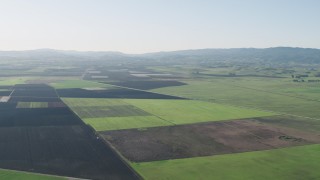 AX70_106 - 4K aerial stock footage Flying over large crop fields to approach Bolsa Road in Hollister, California