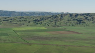 AX70_108 - 4K aerial stock footage Farm fields beside green hills in Hollister, California