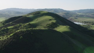 4K aerial stock footage Approach the top of a green hill in Hollister, California Aerial Stock Footage | AX70_129