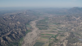 4K aerial stock footage Farm fields and Santa Clara River surrounded by mountains in Piru, California Aerial Stock Footage | AX70_184