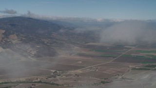 4K aerial stock footage Fly through a cloud to reveal farm fields in Greenfield, California Aerial Stock Footage | AX70_245