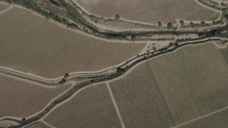 AX70_248 - 4K aerial stock footage bird's eye view of a river by crop fields, reveal Arroyo Seco Road in Greenfield, California