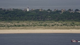 AX71_047E - 5.1K aerial stock footage of a fishing boat passing the beach near Sandy Hook Lighthouse, Middletown, New Jersey