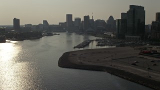 AX73_125E - 5.1K aerial stock footage of office building on by Patapsco River near Downtown Baltimore skyscrapers, Maryland