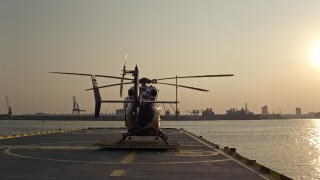 AX73_147 - 5.1K aerial stock footage of Patapsco River seen while lifting off from behind a helicopter on Pier 7, Maryland, sunset