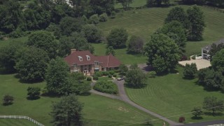 4.8K aerial stock footage of a lone upscale home with green lawns in Clifton, Virginia Aerial Stock Footage | AX74_010