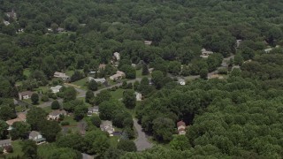 4.8K aerial stock footage flying by suburban homes and lush green trees in Clifton, Virginia Aerial Stock Footage | AX74_011