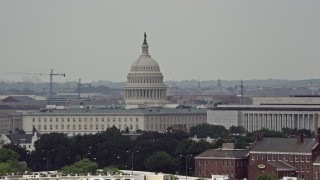 AX74_038E - 4.8K aerial stock footage of the United States Capitol seen while passing smoke stacks in Washington DC