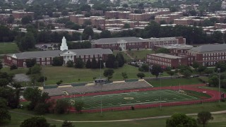 4.8K aerial stock footage of Charles Young Elementary School beside a high school football field in Washington D.C. Aerial Stock Footage | AX74_048